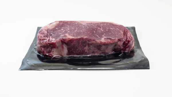 Ωμό κομμάτι βοδινού κρέατος για μπριζόλα σε συσκευασία κενού που απομονώνεται σε λευκό φόντο — Φωτογραφία Αρχείου