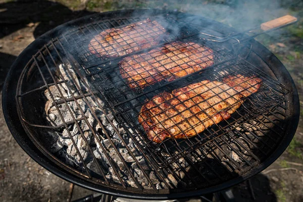 Selective focus of juicy beef steaks grilling on barbecue grid with smoke — Stock Photo, Image