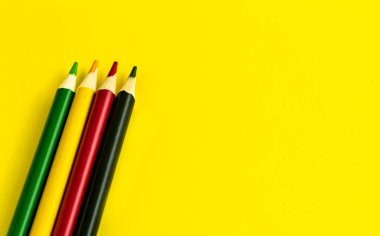 Resim veya metin için kopyalama alanı olan sarı kağıt arkaplan üzerine konulmuş renkli kalem