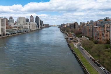Nehir kanalındaki New York City gökdelenleri, bulutlu ve mavi gökyüzü arka planı