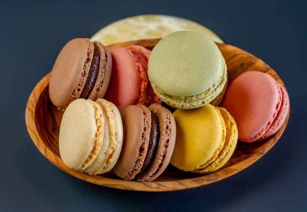 Row of delicious colorful French macaroons of different flavors on black background with copy space. High - quality photo