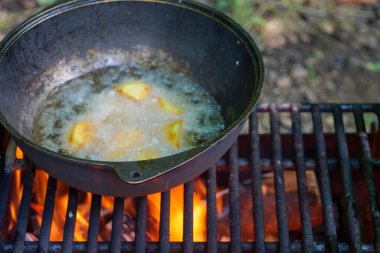 Ruddy Lezzetli Patates, doğada yağlı bir kazanda kızarıyor. Yakın çekim manzarası. Yüksek kaliteli fotoğraf.