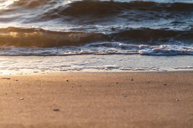 Sahildeki dalgalarda gün batımının güzel yansıması. Yüksek kaliteli fotoğraf..