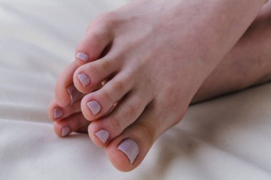 Close-up of female feet painted grey nail polish, self made pedicure at home. High-quality photo