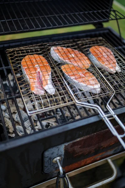 grilled salmon steaks are coking on the firewood, in the backyard. High-quality photo