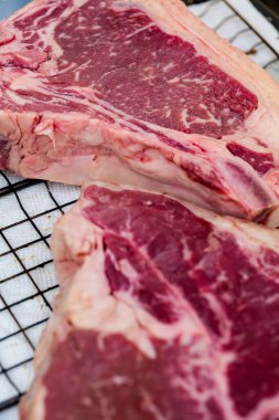 Close up of Fresh cut, raw T-bone steak prepared for cooking on the grill