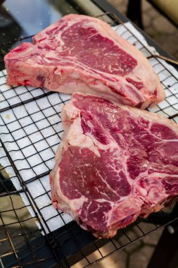 Close up of Fresh cut, raw T-bone steak prepared for cooking on the grill