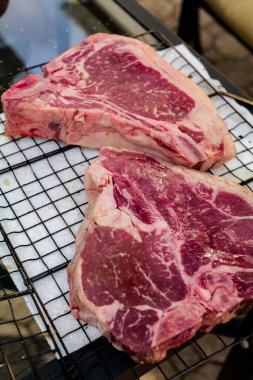Close up of Fresh cut, raw T-bone steak prepared for cooking on the grill