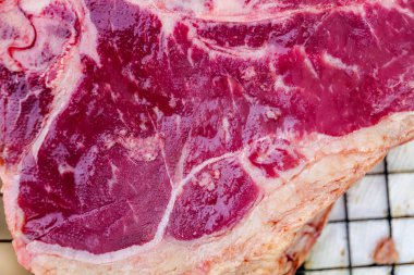 Close up of Fresh cut, raw T-bone steak prepared for cooking on the grill
