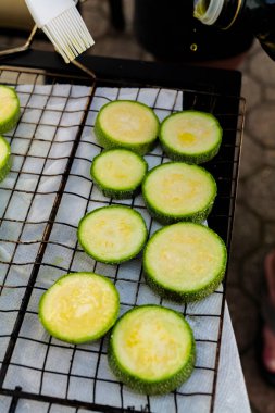 Hand prepares raw sliced vegetables - zucchini, squash, eggplant roasting on the grill. High quality photo