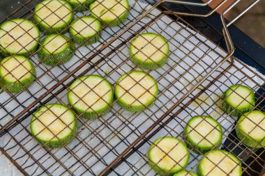 Hand prepares raw sliced vegetables - zucchini, squash, eggplant roasting on the grill. High quality photo