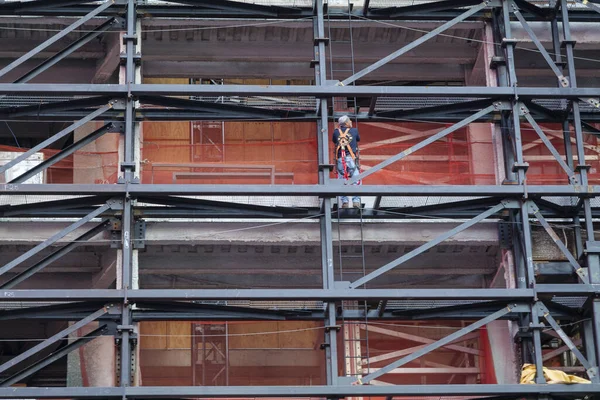 İskelede geriye doğru duran bir adam, yeni inşaat ve yenileme konsepti. - New York. Yüksek kaliteli fotoğraf.