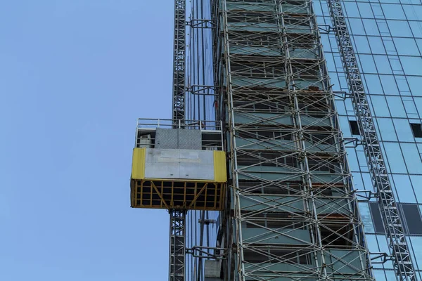Elevator lifts for workers and materials at the construction site of a new skyscraper building. High-quality photo