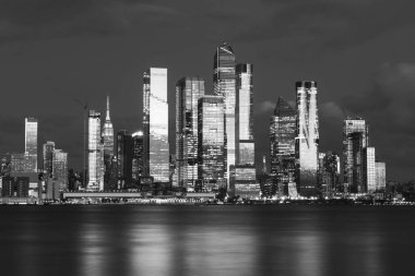 Manhattan şehir merkezi ufuk çizgisi, Hudson Nehri 'nin karşısından gece görülmüş. Güzel yansımalar ve ışık. Yüksek kalite fotoğraf