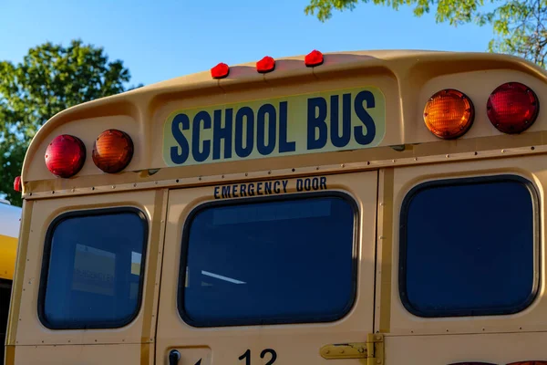 Top of a yellow school bus with lights and text. Closeup against blue sky in the fall. Back to school concept. Copy space. High quality photo