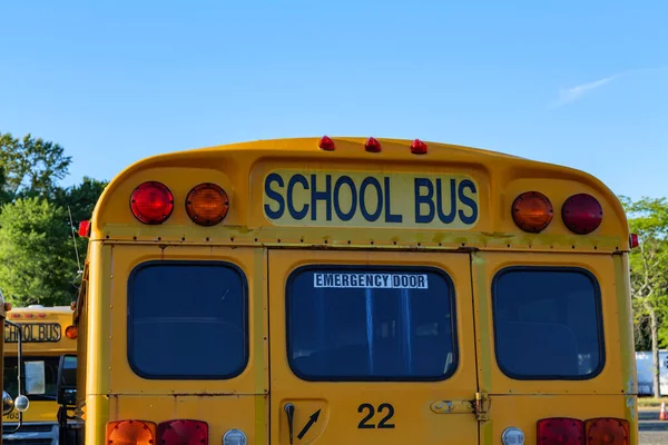 Top of a yellow school bus with lights and text. Closeup against blue sky in the fall. Back to school concept. Copy space. High quality photo