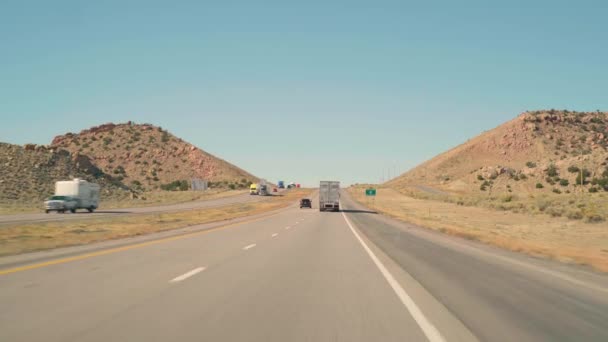 В ясный день военнопленный едет в гору по шоссе 40 Аризона за грузовиком — стоковое видео
