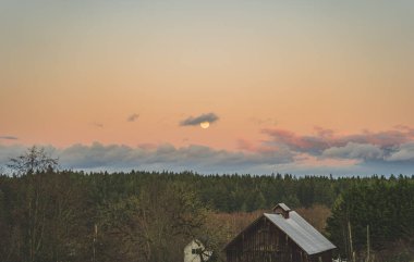 İlçe sahnesinde yükselen sarı aylı dramatik akşam gökyüzü 