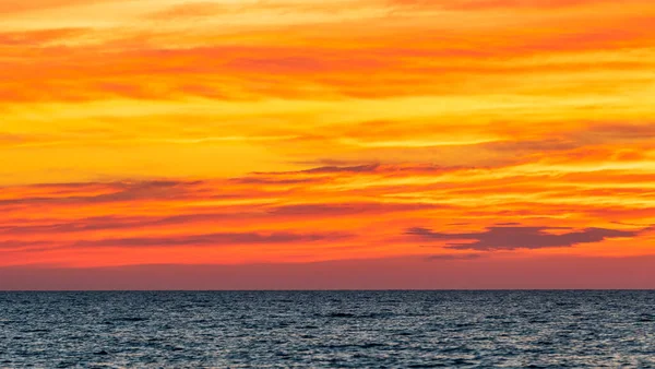 Élénk narancssárga naplemente ég és felhők az óceán felett — Stock Fotó