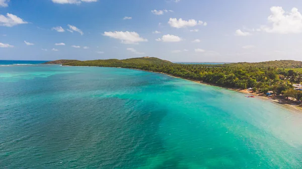 High angle view of Reserva Natural Cabezas de San Juan in Fajardo, Puerto Rico. Faro Las Cabezas de San Juan lighthouse of the heads of San Juan sits on the hill. blue water and puffy clouds, 