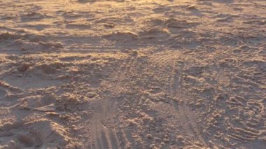 Florida körfezi üzerinde gün batımında dalgalar çökerken kumlu sahilden yukarı doğru eğil.