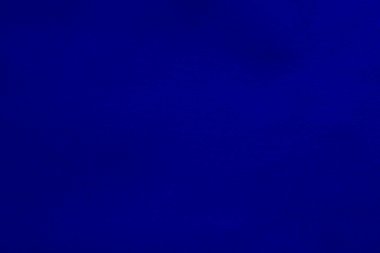 Arka plan olarak mavi kadife kumaş dokusu kullanılıyor. Yumuşak ve pürüzsüz tekstil malzemelerinin boş mavi kumaş arka planı. Metin için boşluk var.