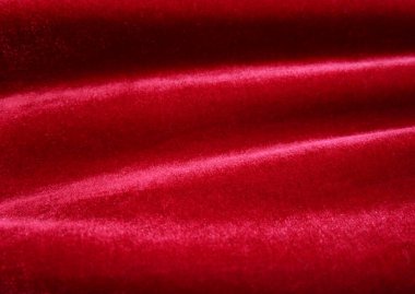 Arka plan olarak kırmızı kadife kumaş dokusu kullanılıyor. Yumuşak ve pürüzsüz tekstil malzemelerinden oluşan boş kırmızı kumaş arka plan. Metin için boşluk var..
