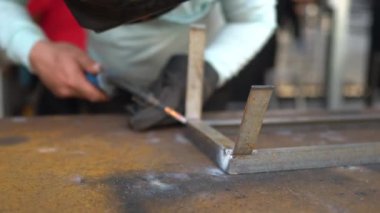 Erkek işçi elektrikli çelik kaynakçılığı yapıyor. Çelik işçiliği. Yavaş çekim videosu. Kıvılcım aşırı yüklenmesi