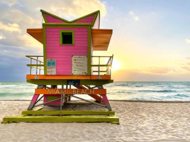 Miami Beach 'te ikonik turuncu ve pembe cankurtaran kulübesi. Güneşin doğuşunda güzel gökyüzü.