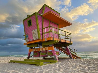 Miami Beach 'te ikonik turuncu ve pembe cankurtaran kulübesi. Güneşin doğuşunda güzel gökyüzü.