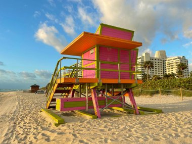 Miami Beach 'te ikonik turuncu ve pembe cankurtaran kulübesi. Güneşin doğuşunda güzel gökyüzü.