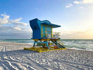 Iconic blue and yellow lifeguard house in Miami Beach. Beautiful sky at sunrise.