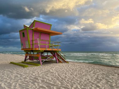 Miami Beach 'te ikonik turuncu ve pembe cankurtaran kulübesi. Güneşin doğuşunda güzel gökyüzü.