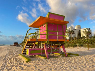 Miami Beach 'te ikonik turuncu ve pembe cankurtaran kulübesi. Güneşin doğuşunda güzel gökyüzü.
