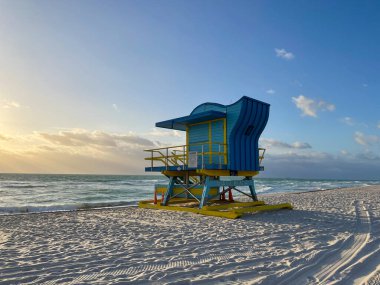 Iconic blue and yellow lifeguard house in Miami Beach. Beautiful sky at sunrise.