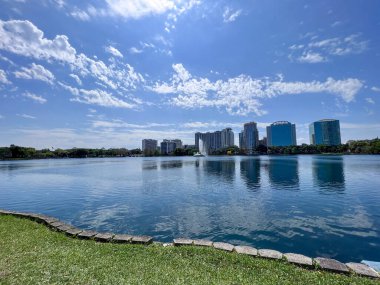 Lake Eola Park in downtown Orlando, Florida. Large commercial buildings in the background.