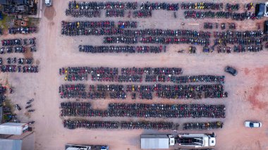 Terk edilmiş arabalardan oluşan bir bahçe ve polis tarafından usulsüzlükten dolayı el konulmuş. Bir sürü arabası ve bir sürü motosikleti var. Hava görünümü