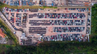 Terk edilmiş arabalardan oluşan bir bahçe ve polis tarafından usulsüzlükten dolayı el konulmuş. Bir sürü arabası ve bir sürü motosikleti var. Hava görünümü