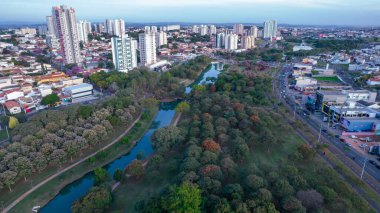 Indaiatuba Ekoloji Parkı. Şehir merkezinde gölü, ağaçları ve evleri olan güzel bir park. Hava görünümü.