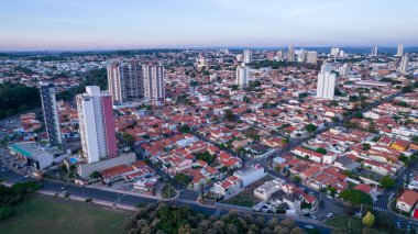 Indaiatuba Ekoloji Parkı. Şehir merkezinde gölü, ağaçları ve evleri olan güzel bir park. Hava görünümü.