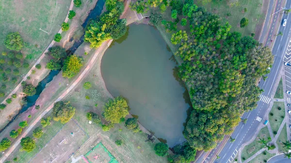 Indaiatuba Ekoloji Parkı. Şehir merkezinde gölü, ağaçları ve evleri olan güzel bir park. Hava görünümü.