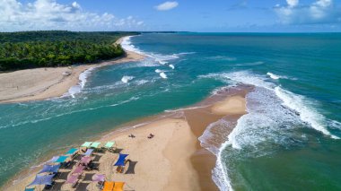 Aerial view of Caraiva beach, Porto Seguro, Bahia, Brazil. Colorful beach tents, sea and river.