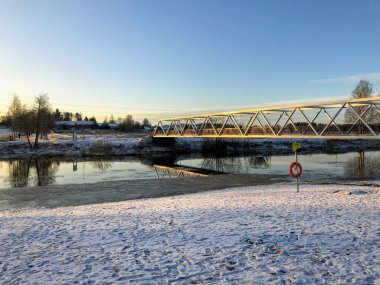 Güneşli bir kış gününde nehrin üzerindeki köprüyle manzara