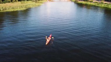 İki adam nehirde kano yapıyor. Drone görünümü.