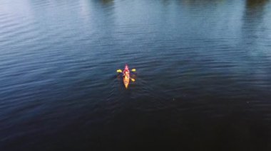İki adam nehirde kano yapıyor. Drone görünümü.