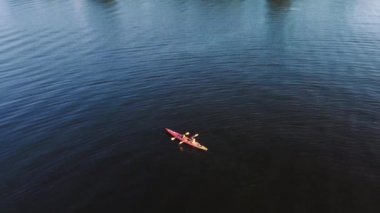 İki adam nehirde kano yapıyor. Drone görünümü.