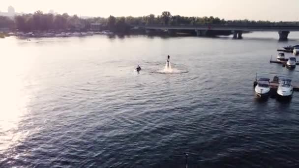 Junger Mann Sitzt Auf Einem Fliegenbrett Der Nähe Der Seebrücke — Stockvideo