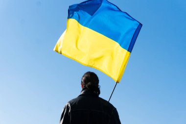 Genç adam Ukrayna bayrağını sahada tutuyor. Vatansever
