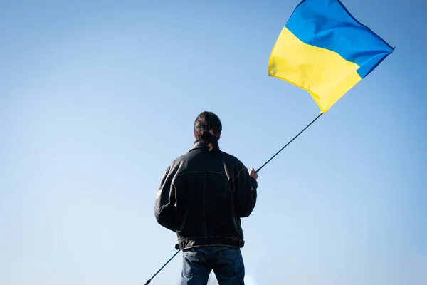 Der junge Mann hält die ukrainische Fahne auf dem Feld. patriot. — Stockfoto