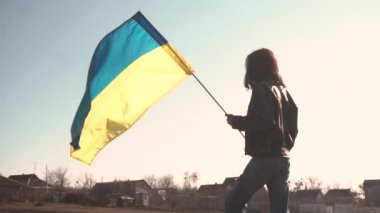 Genç adam Ukrayna bayrağını sahada tutuyor. Vatansever.